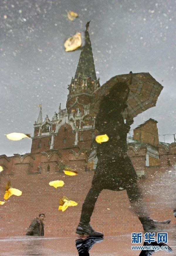 Một người phụ nữ cầm ô bước qua Điện Kremlin khiến bóng cô ấy in xuống mặt đường đầy nước sau cơn mưa ngày 12/10/2006. Điện Kremlin nằm giữa trung tâm thành phố Moskva, là một trong những quần thể kiến trúc lớn nhất trên thế giới (Nguồn: Xinhuanet)
