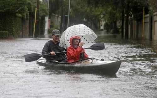 Paul Banker và vợ Wink Banker chèo thuyền kayak trên đường phố bị ngập lụt ở Charleston, Nam Carolina. (ảnh: AP).