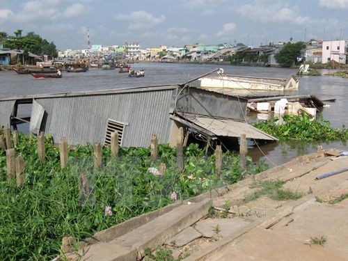 Bờ sông Cần Thơ đoạn qua ấp Nhơn Lộc 1, thị trấn Phong Điền, bị sạt lở dài kéo theo 4 căn nhà đổ xuống sông (Ảnh: Trần Khánh Linh/TTXVN)
