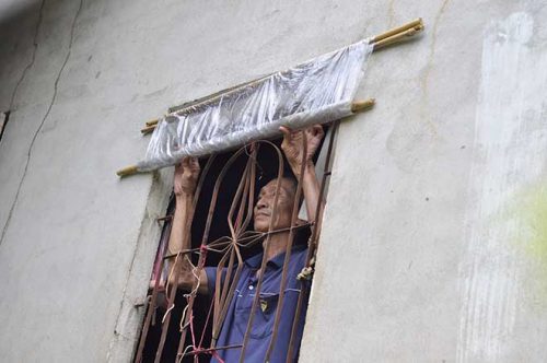 Không được sửa nhà, ông Phạm Văn Thay (57 tuổi) dùng cửa sổ bằng nilông để tránh mưa nắng
