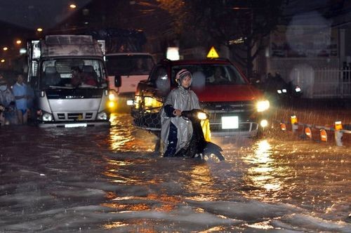 Người dân vất vả lưu thông trong trời mưa, đường bị ngập sâu ở TP Biên Hòa, tỉnh Đồng Nai (Ảnh: Xuân Hoàng)