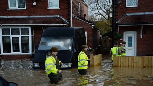 Nhân viên cứu hỗ giúp người dân sơ tán (Ảnh: Daily Mail)
