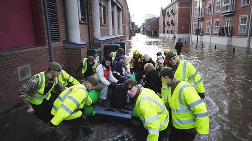 Nhân viên cứu hộ giúp người dân đến nơi sơ tán (Ảnh: Daily Mail)