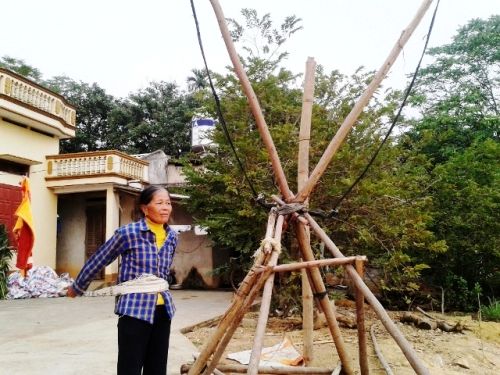 Bà Dương Thị Chiến đang mô tả lại cách xử dụng nỏ cao su bắn đá để đuổi những chiếc tàu cuốc.