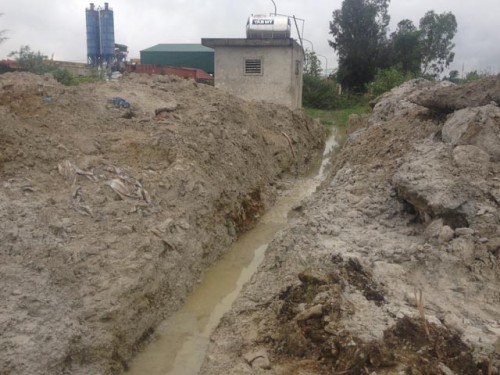 Nước thải chưa qua xử lý và chất thải rắn đổ ra ngay trên đường dân sinh khiến người dân ở đây đi lại khó khăn (Ảnh: CT)