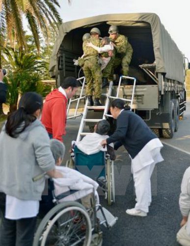 Lực lượng cứu hộ di chuyển các nạn nhân bị thương trong trận động đất. (Nguồn: Kyodo/TTXVN)