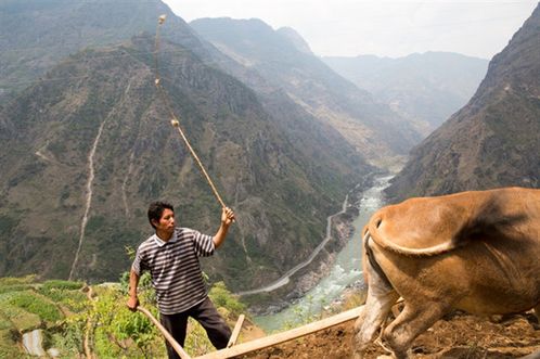 Một nông dân đang làm nương ở tỉnh Vân Nam, xa xa là dòng Nộ Giang hùng vĩ (Ảnh: New York Times)