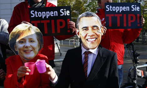 Người biểu tình phản đối TTIP đeo mặt nạ bà Merkel và ông Obama. Ảnh: Reuters. 