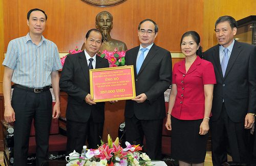 Chủ tịch Ủy ban Trung ương MTTQ Việt Nam Nguyễn Thiện Nhân tiếp nhận số tiền quyên góp của Chính phủ và nhân dân Lào anh em. Ảnh: VGP/Hoàng Long 