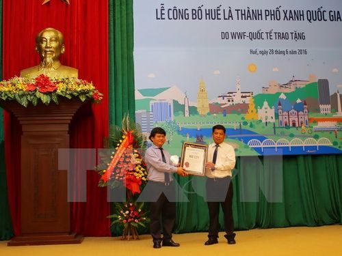 Đại diện lãnh đạo thành phố Huế (trái) đón nhận danh hiệu "Thành phố xanh quốc gia 2016" do WWF trao tặng (Ảnh: Hồ Cầu/TTXVN)