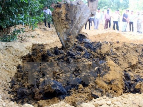 Lực lượng chức năng dùng máy xúc để đào chất thải của Công ty Formosa Hà Tĩnh chôn lấp tại trang trại ông Lê Quang Hòa, tại phường Kỳ Trinh, thị xã Kỳ Anh. (Ảnh: Phan Quân/TTXVN)