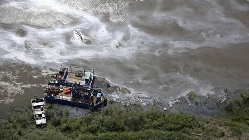 Các công nhân cố gắng làm sạch vụ tràn dầu trên sông Bắc Saskatchewan (Nguồn: The Canadian Press)