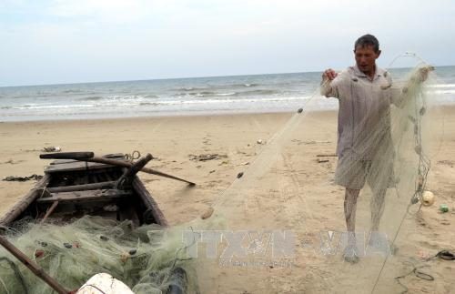  Ngư dân tại xã Kỳ Ninh, thị xã Kỳ Anh, Hà Tĩnh thu gom lưới sau chuyến ra khơi đánh bắt cá trở về (Ảnh: Công Tường/TTXVN)