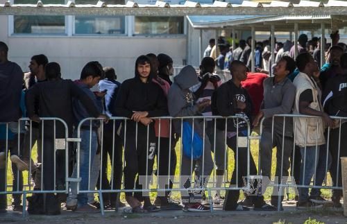 Người di cư xếp hàng nhận lương thực cứu trợ tại Calais, Pháp ngày 22/8 (Ảnh: AFP/TTXVN)