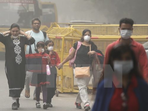 Người dân đeo khẩu trang để tránh tác hại của khói mù ô nhiễm ở New Delhi, Ấn Độ ngày 6/11. (Nguồn: AP/TTXVN)